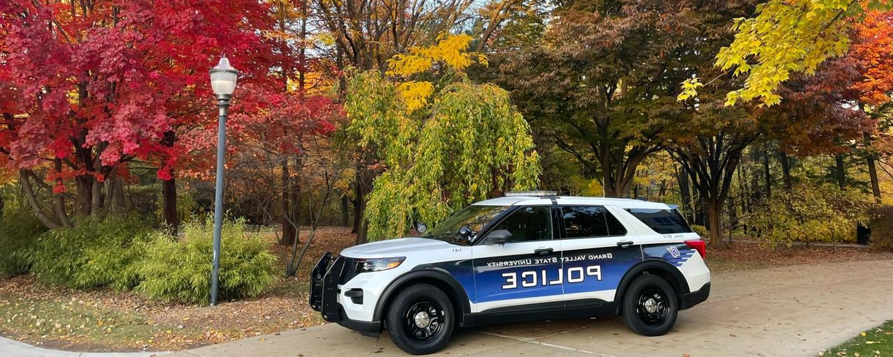 GVPD Police cruiser parked on path in front of colorful trees in autumn